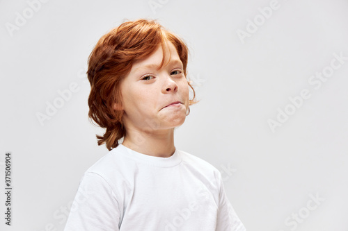 redhead boy white t-shirt cropped view studio gray background 