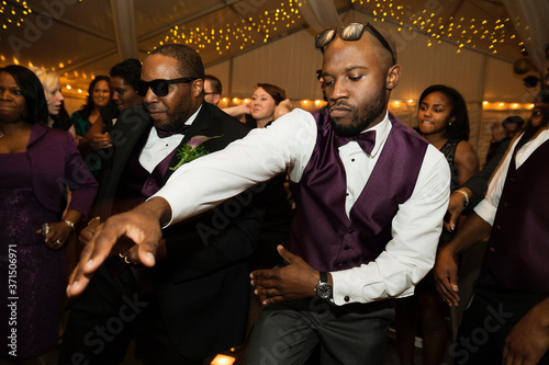 Groom and groomsman dancing at reception photo