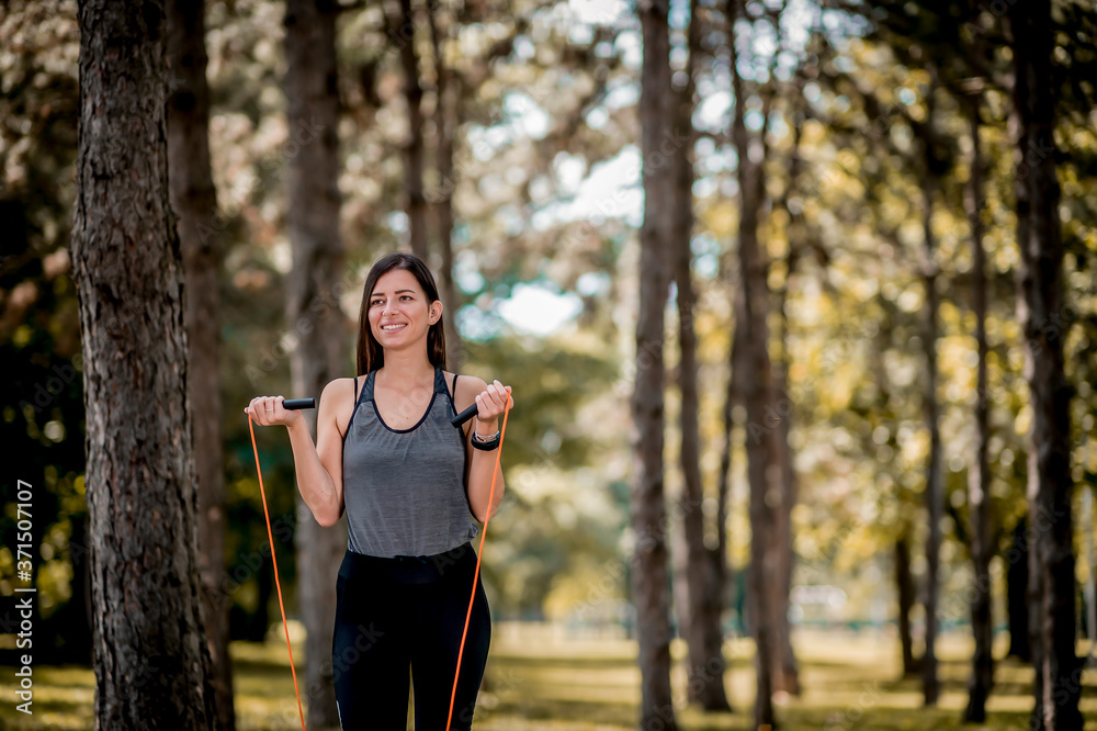 Young woman exercising with jumping rope at public park Young woman exercising with jumping rope at public park