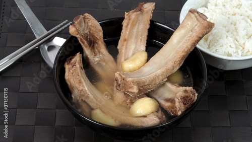 Bak kut teh or pork ribs soup which made from many ingredients such as big garlic, white pepper and many spices. Very popular traditional authentic menu dish in Singapore and Malaysia. Serve with rice photo