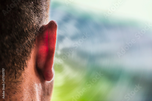 Close up of ear of Caucasian man and sound waves