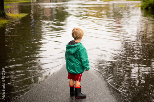 Caucasian boy wearing puddles near flood photo