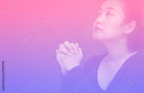 Asian Woman praying and worship to GOD Using hands to pray in religious beliefs and worship christian in the church or in general locations in vintage color tone or copy space.