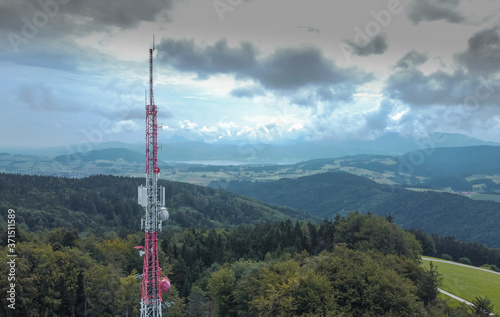 Big antenna mast for 3G  4G and 5G repeater in the middle of the forest or nature. Controversial tehnology in the wild nature. Panoramic view.