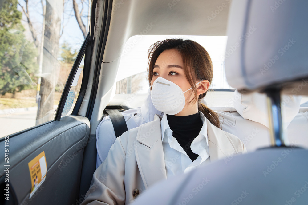 The young woman wearing a mask by car The young woman wearing a mask by car