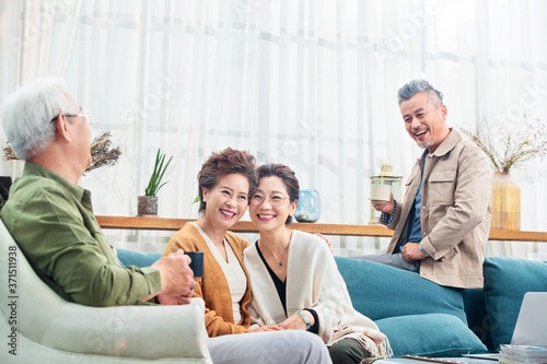 Happy middle-aged couples chat over a cup of tea photo