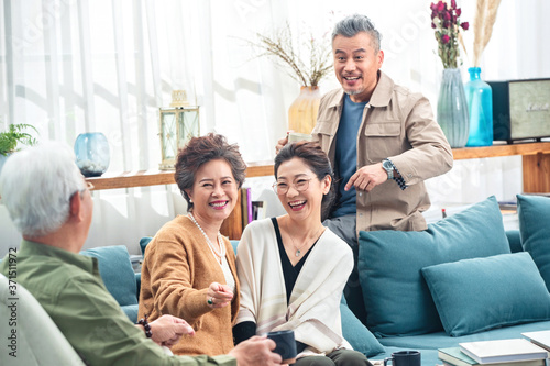 Middle-aged couples chat over a cup of tea photo