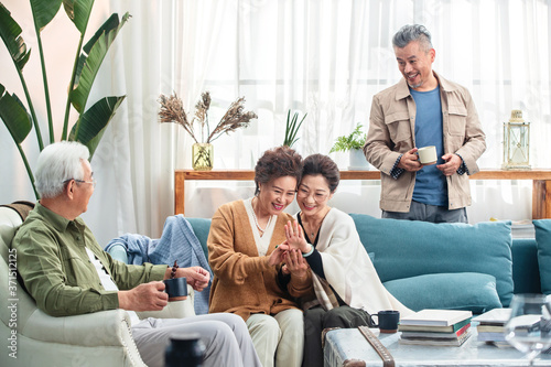 Happiness of the elderly in the sitting room to chat over a cup of tea photo