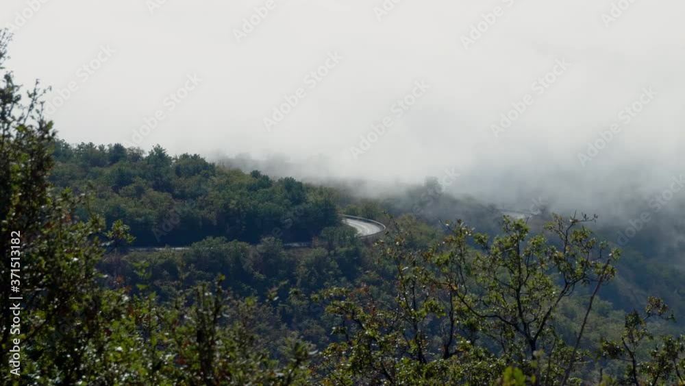 Stunning view of an empty country road in the mountains covered with thick clouds. 4K Stunning view of an empty country road in the mountains covered with thick clouds. 4K