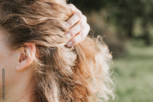 small intra channel hearing aid in the ear of a woman