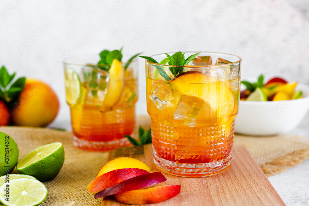 Cocktail with peach, mint and lime and ice cubes Cocktail with peach, mint and lime and ice cubes