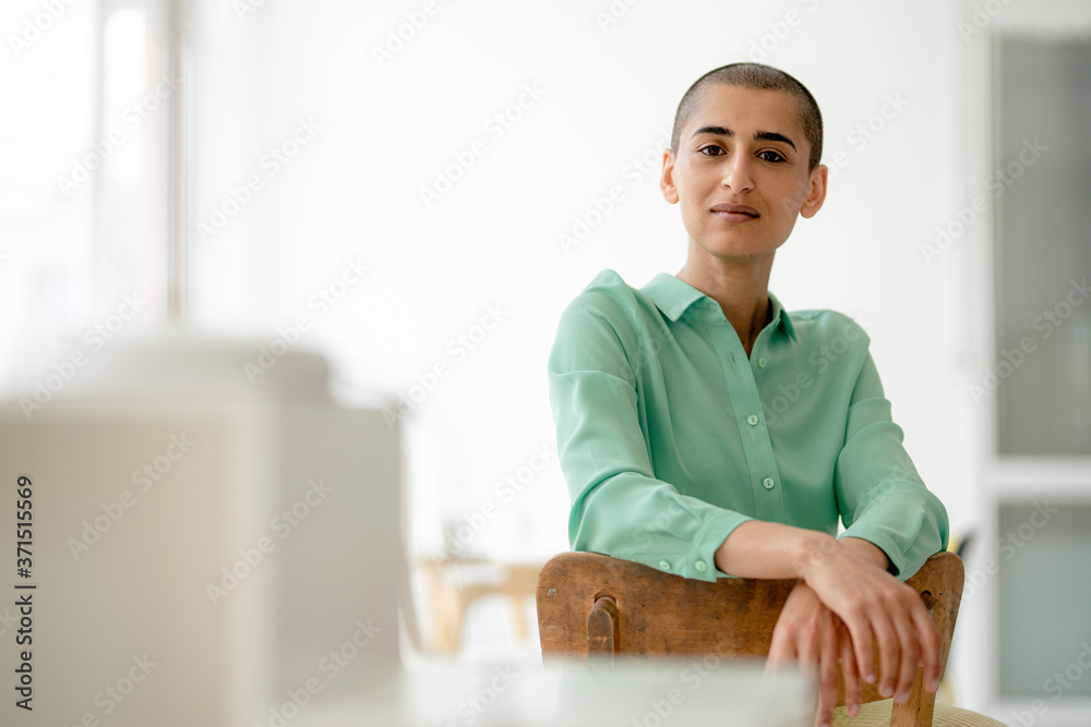 Portrait of a confident woman sitting on chair in a loft Portrait of a confident woman sitting on chair in a loft