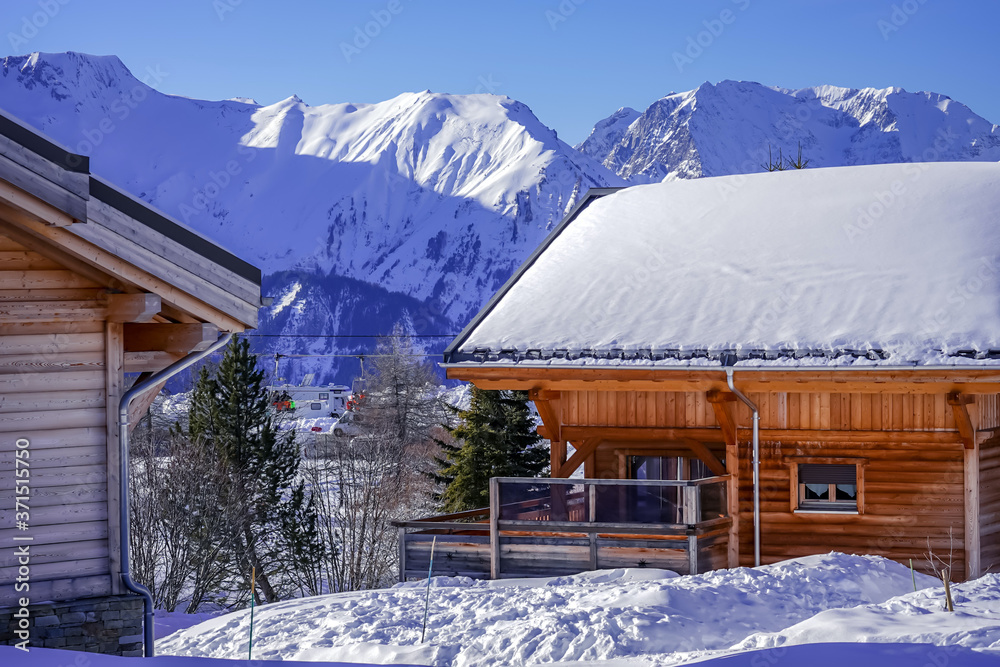 Wooden Ski Chalet In Snow, Mountain View. Beautiful view of French Alps full of snow winter. Food prints in the snow