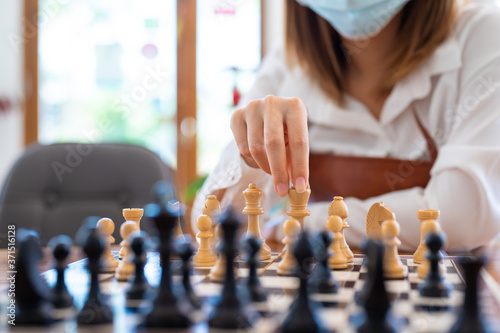 Woman playing chess in club, leisure activity of weekend and compitetion concept. photo