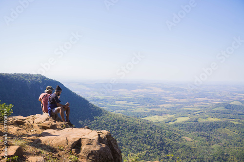 Amigos sentados en la punta de una colina