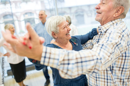 Group of active senior attending dance course in retirement home