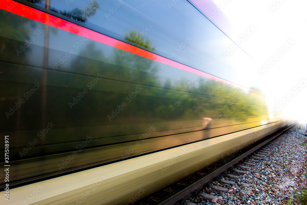Naklejka premium Train in movement by rail with a blue sky