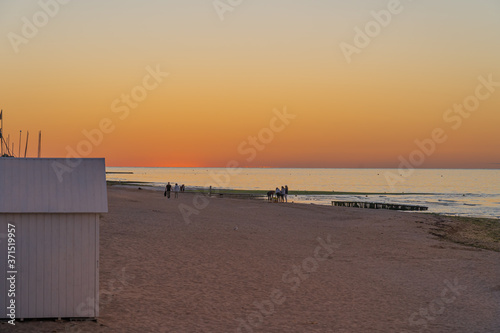 Langrune Sur Mer, France - 08 04 2020: Beach cabins on the beach at sunset along the pear