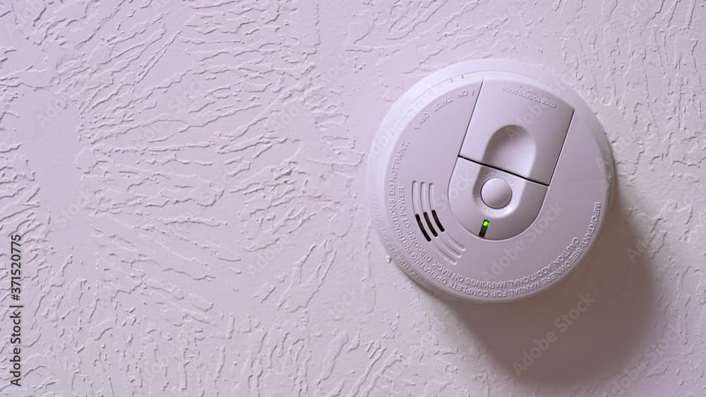 Dead and low battery indicator light and beeping chirp on a smoke detector mounted on the ceiling