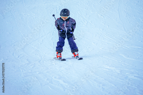 Soft focus background. Young boy skiing downhill in ski resort. Winter season. 