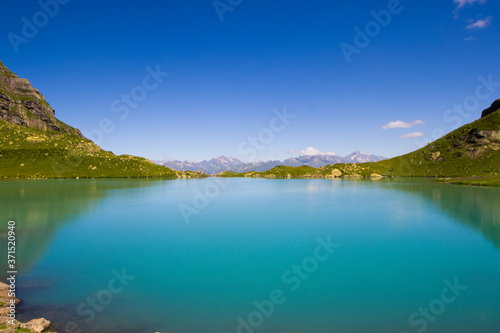 Alpine mountain lake at the daytime, sunlight and colorful landscape