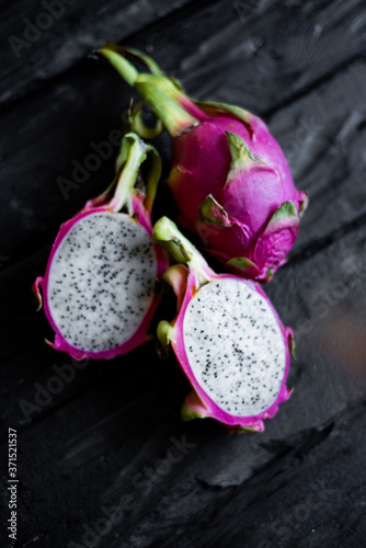 Close up view of exotic dragon fruit sliced isolated on a wooden background. Fresh vegetarians vitamin delicious food. Beautiful picture of summer vacation fruits