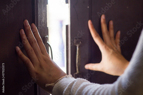 Women hand is opening the door or push the door into outside from the temple, Beautiful old wooden door and sunshine in the morning for concept design