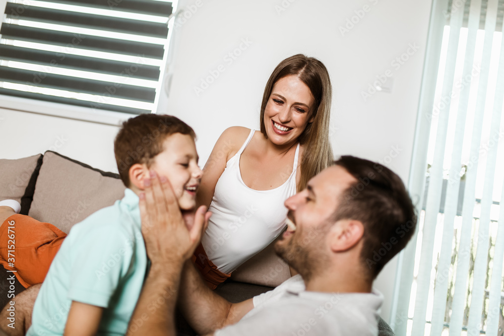 Young beautiful family in casual home look lies on a cozy carpet in the living room. Young beautiful family in casual home look lies on a cozy carpet in the living room.