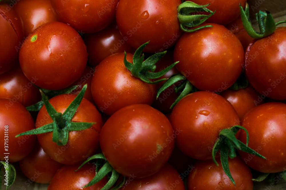 top photo of red cherry tomatoes with green tails top photo of red cherry tomatoes with green tails
