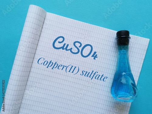 Blue copper(II) sulfate solution in a flask with chemical formula of copper sulfate molecule. It is used in horticulture as a fungicide and herbicide or in swimming pools as an algicide. photo