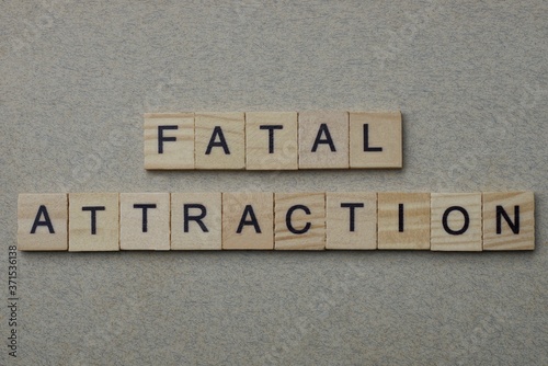 phrase fatal attraction made from gray wooden letters lies on a background photo