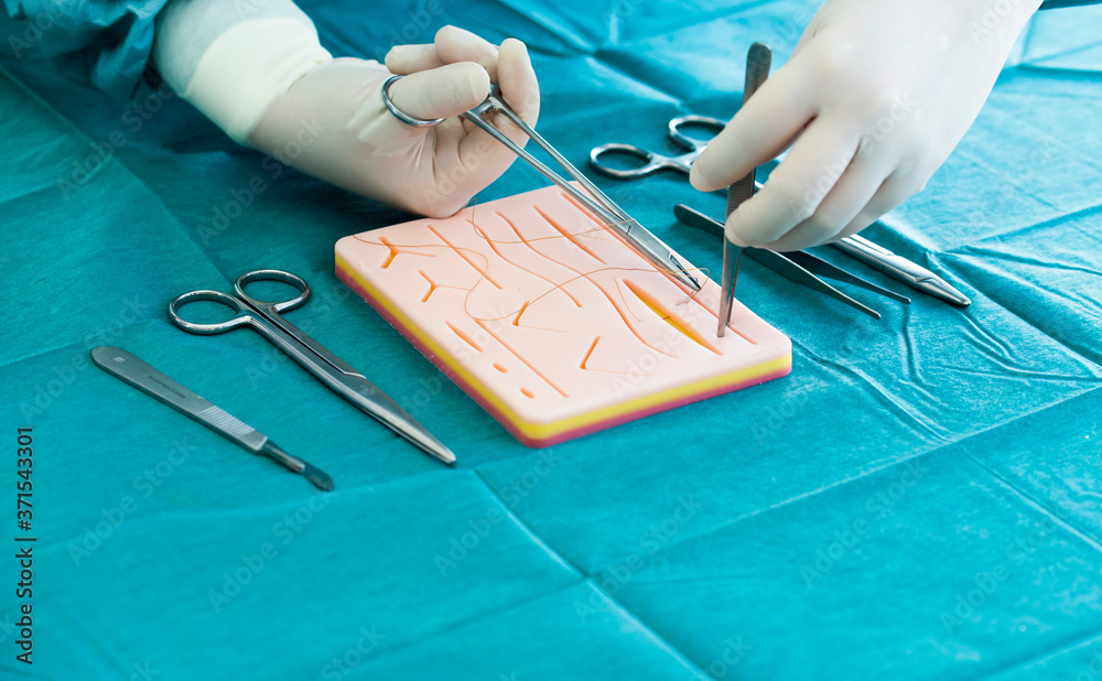Doctor teaches the technique of suturing and closure on silicone pad ...