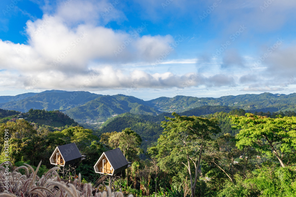 Small cabins in the wood with mountain background Small cabins in the wood with mountain background