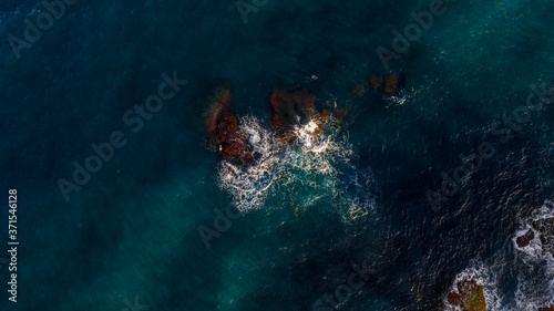 waves hitting two small rocks in top view   mediterranean sea   Spain   aerial view 