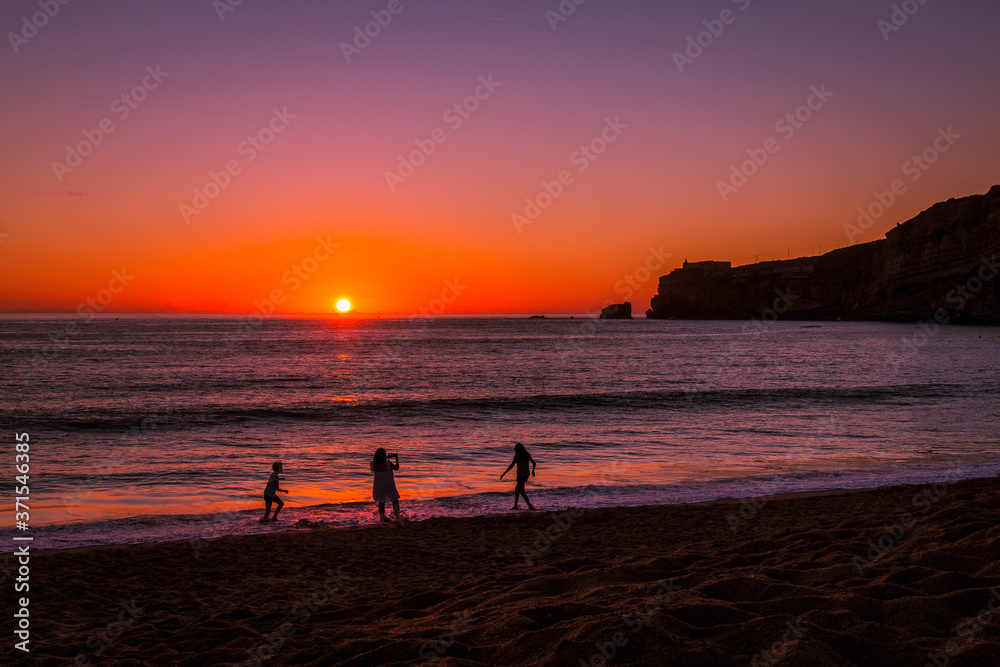 Beautiful sunset at the beach in the village of Nazare, Portugal