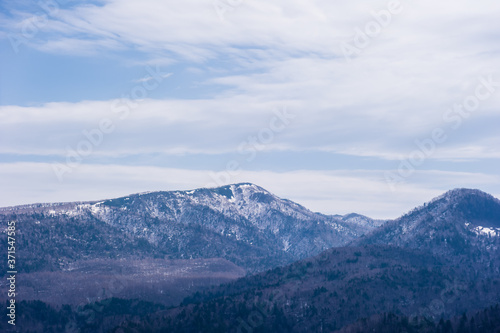 Beautiful winter landscape. Mountain and forest covered with snow  background blue sky.