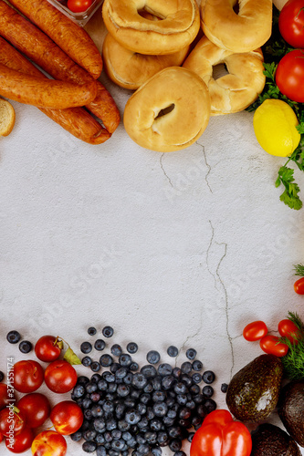 Healthy food concept. Fruits, bagels and sausage on white table.