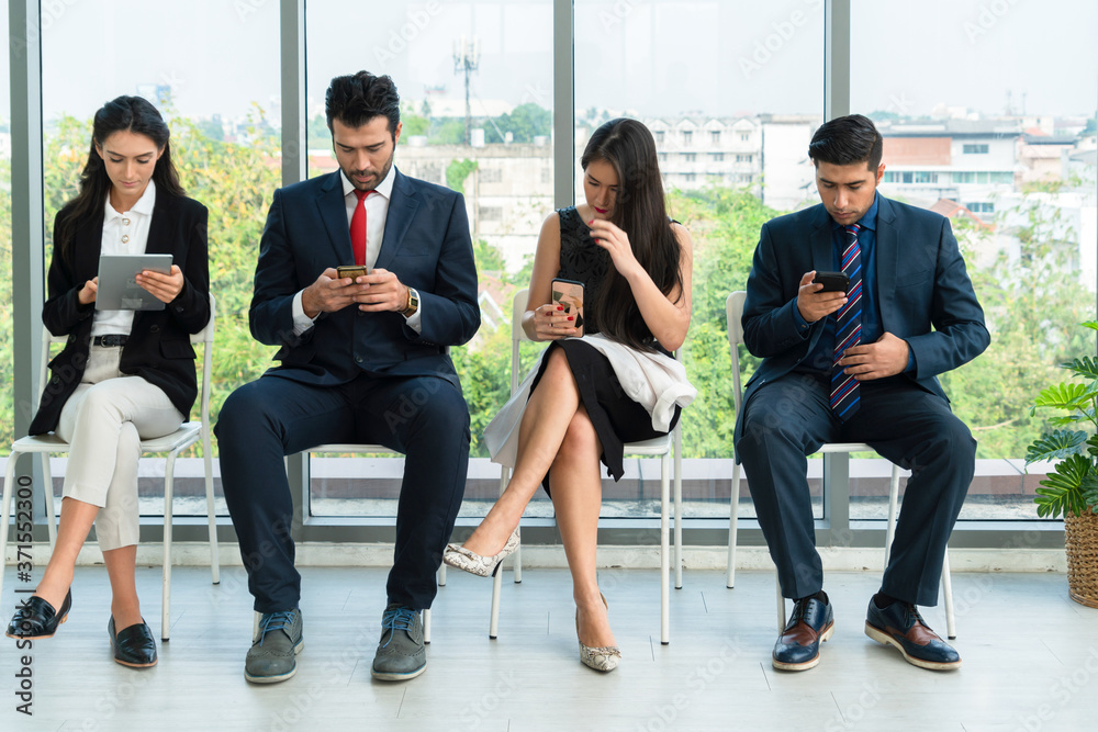 Job seekers and applicants waiting for interview on chairs in office