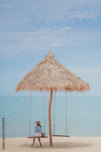 Summer vocation concept   Young woman  wearing stylish blue dress and straw hat with blue sky background on the beach.Cover banner concept.