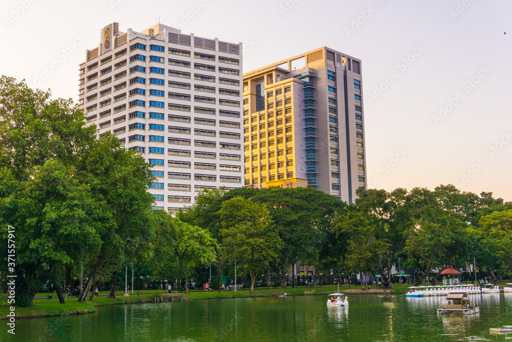 Lumpini park business district Bangkok cityscape from park with sunset sky