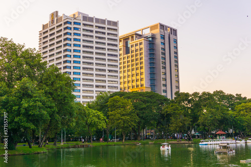 Lumpini park business district Bangkok cityscape from park with sunset sky