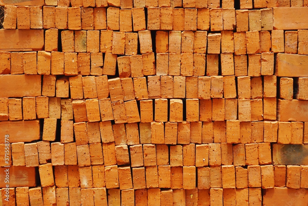 Fototapeta premium Clay bricks stacked in irregular rows abstract horizontal background texture