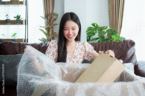 Wall Mural Asian woman unpack packaging after online shopping from discount store
