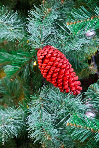 closeup of red painted cone hanging on the christmas tree branch. New year and Christmas time concept