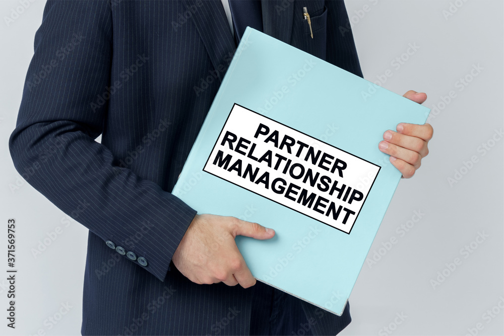 A businessman holds a folder with documents, the text on the folder is - PARTNER RELATIONSHIP MANAGEMENT A businessman holds a folder with documents, the text on the folder is - PARTNER RELATIONSHIP MANAGEMENT