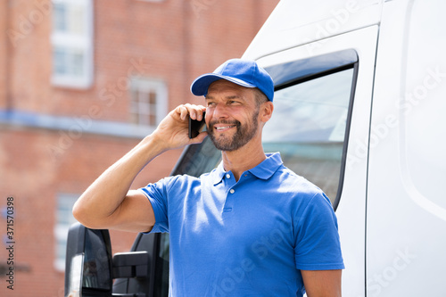 Handyman Men Talking On Mobile Phone Near Truck