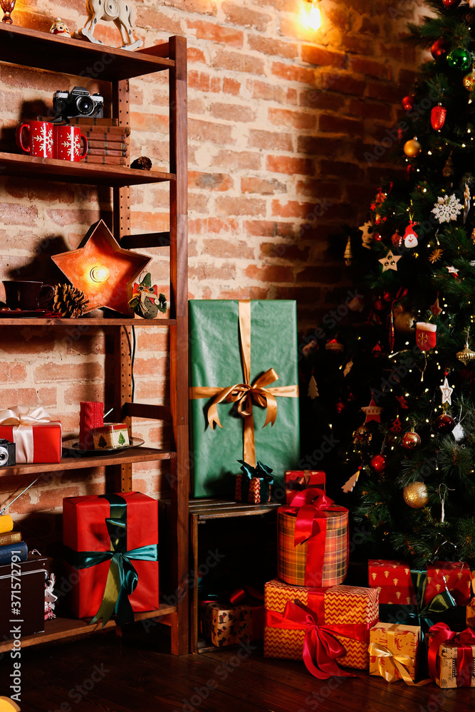 Brightly lit christmas tree with lots of gifts near brick wall