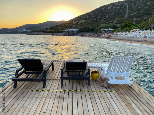 empty beach and sunbeds in the evening  lounge chair standing on the pier