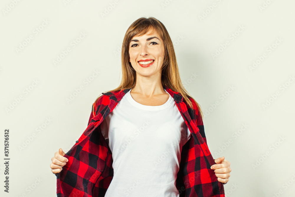 Young woman with a smile in a red shirt and white t-shirt on a white background. Concept template for text, logo, shock, surprise. Banner Young woman with a smile in a red shirt and white t-shirt on a white background. Concept template for text, logo, shock, surprise. Banner
