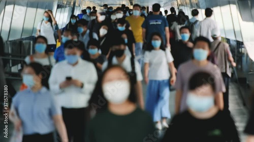 Slow motion of blurred unrecognized people wearing medical face masks at metro in Hong Kong.	